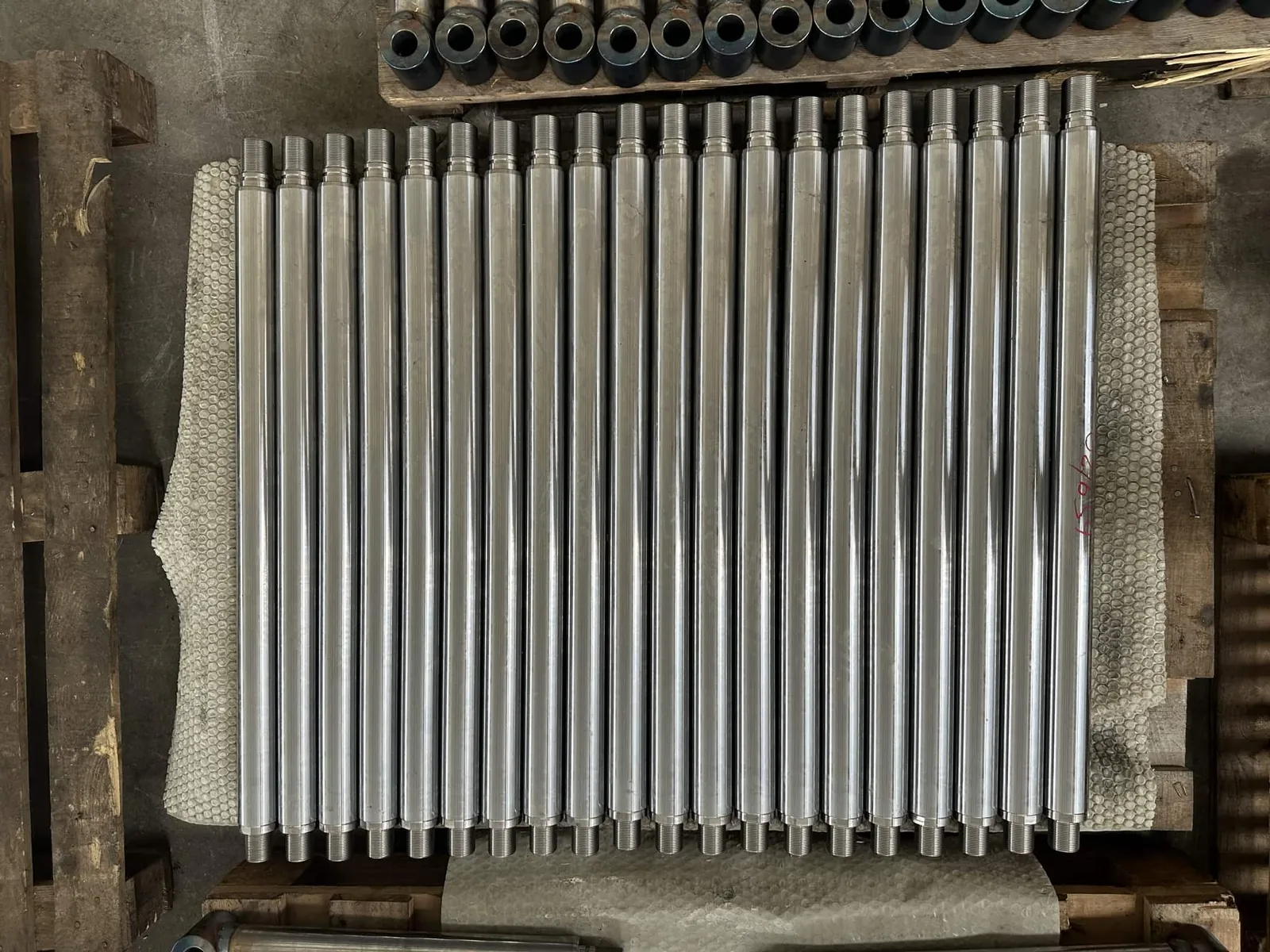 Batch of turned piston rods in a crate