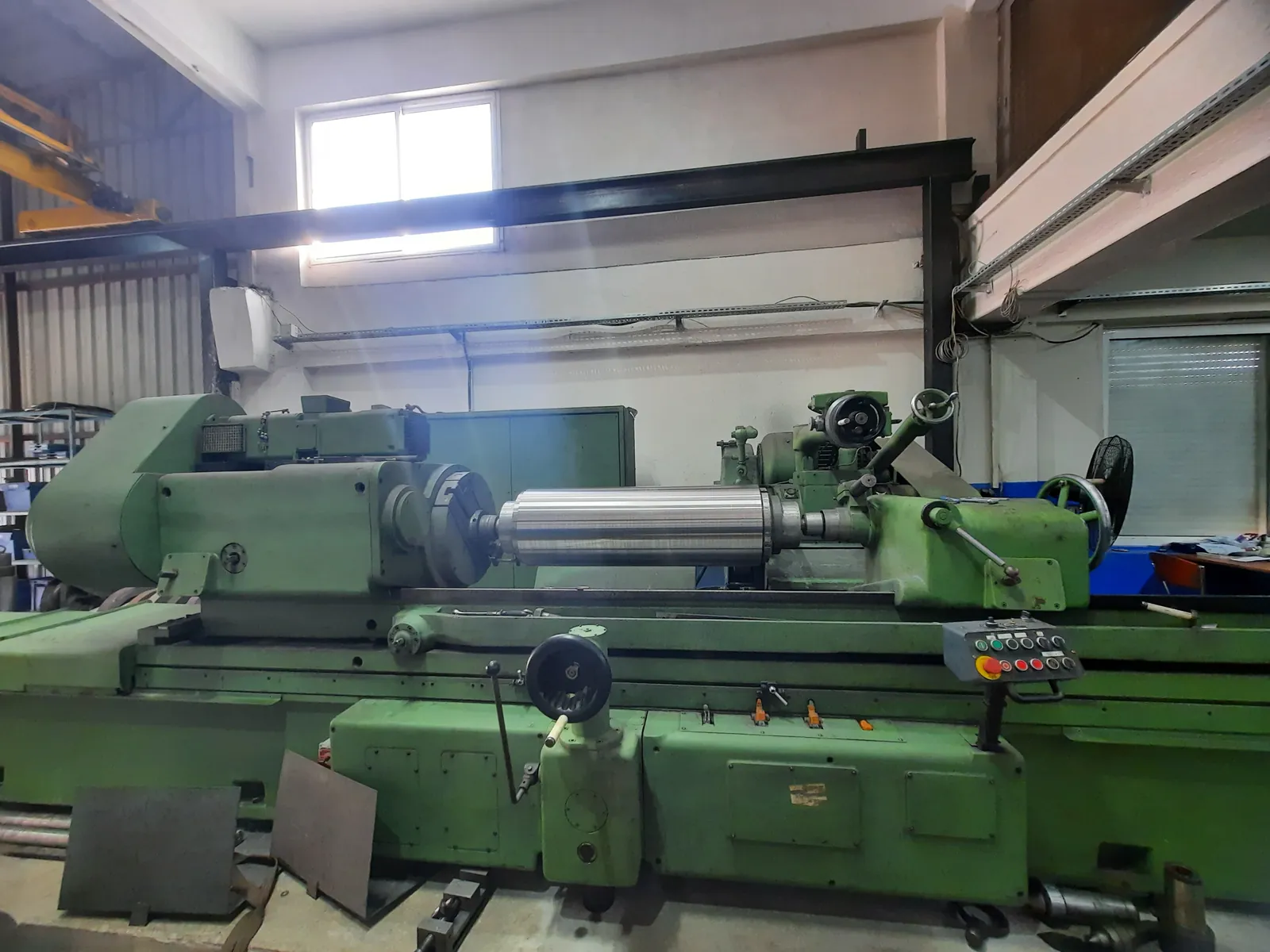 Cylindrical grinding machine grinding a steel roll