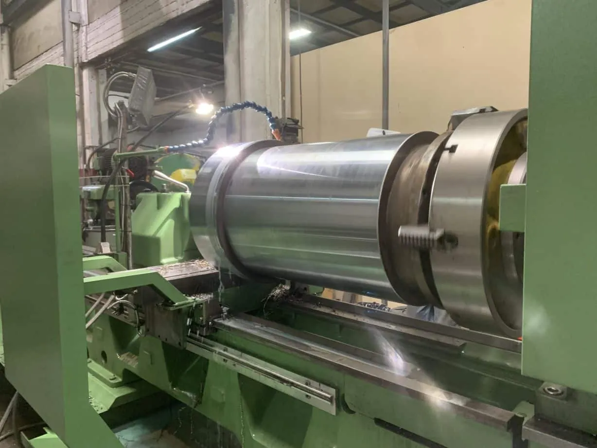 Cylindrical roller shell clamped in chuck on heavy lathe